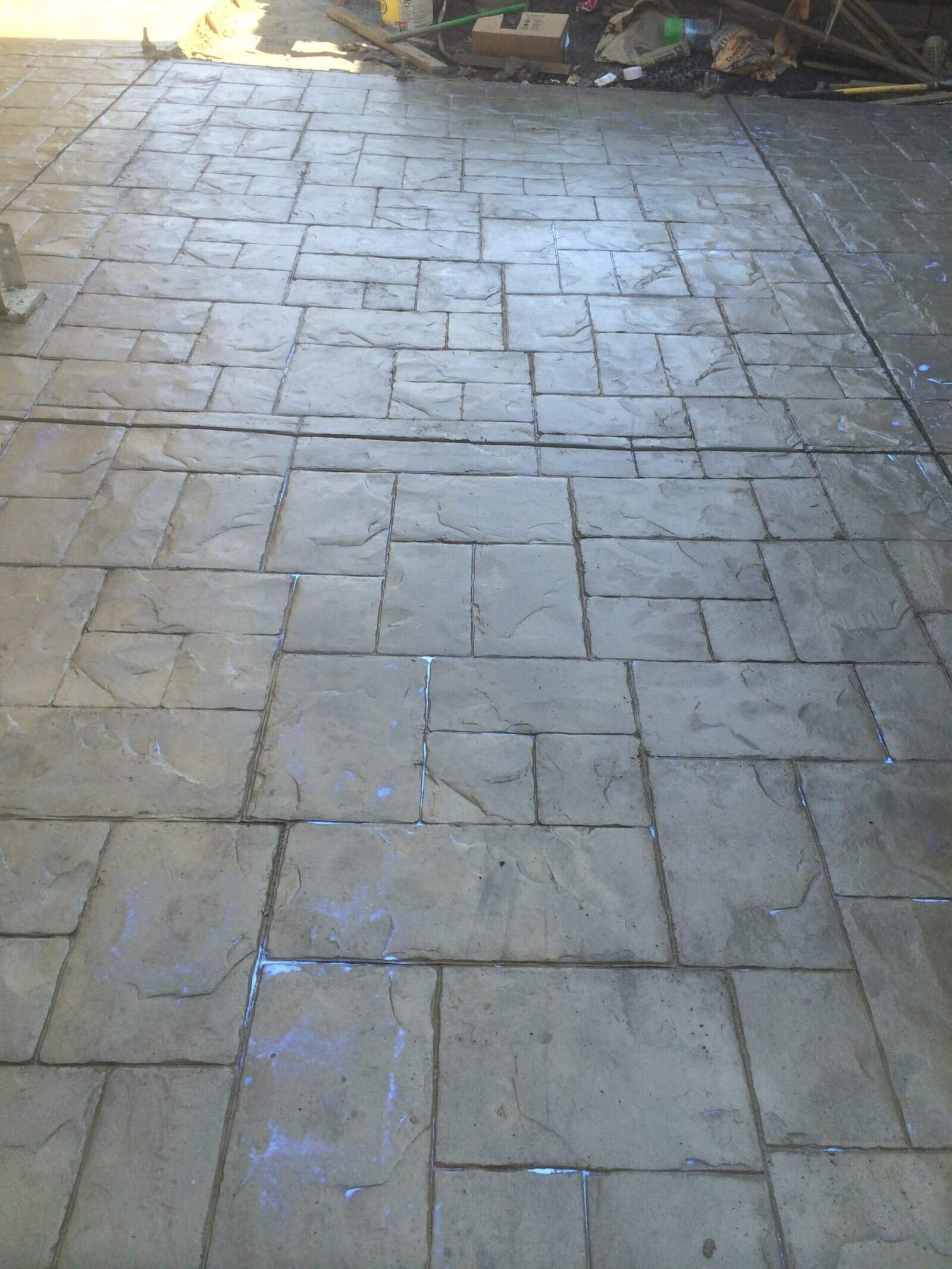 Stained concrete patio with stamped stone pattern, fresh and newly installed.