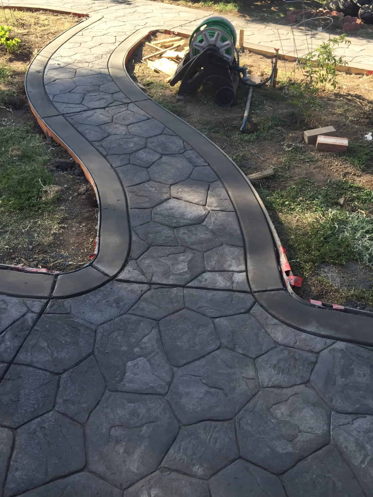 Concrete stamped walkway with hexagonal pattern opening and curving design.